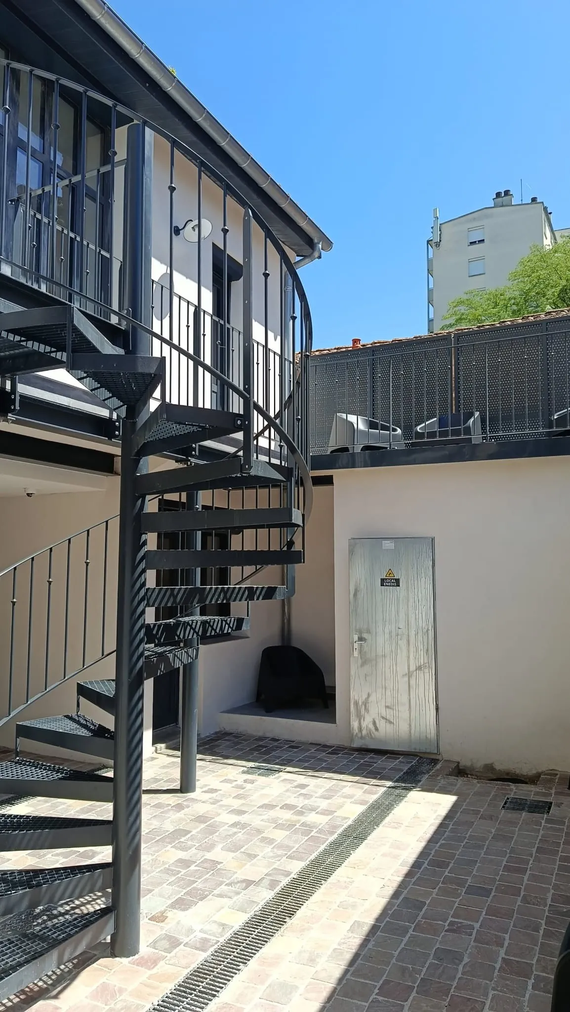 Départ d'escalier et cour intérieure pavée